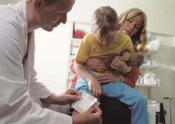 Doctor placing bandage on child's leg