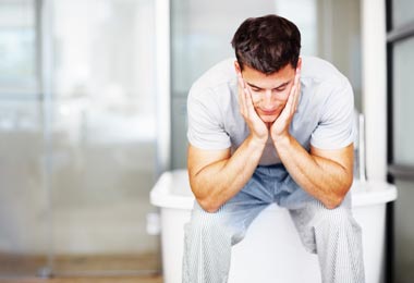 Disappointed man holding his head in his hands while sitting