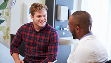 Young man speaking with doctor in doctors office