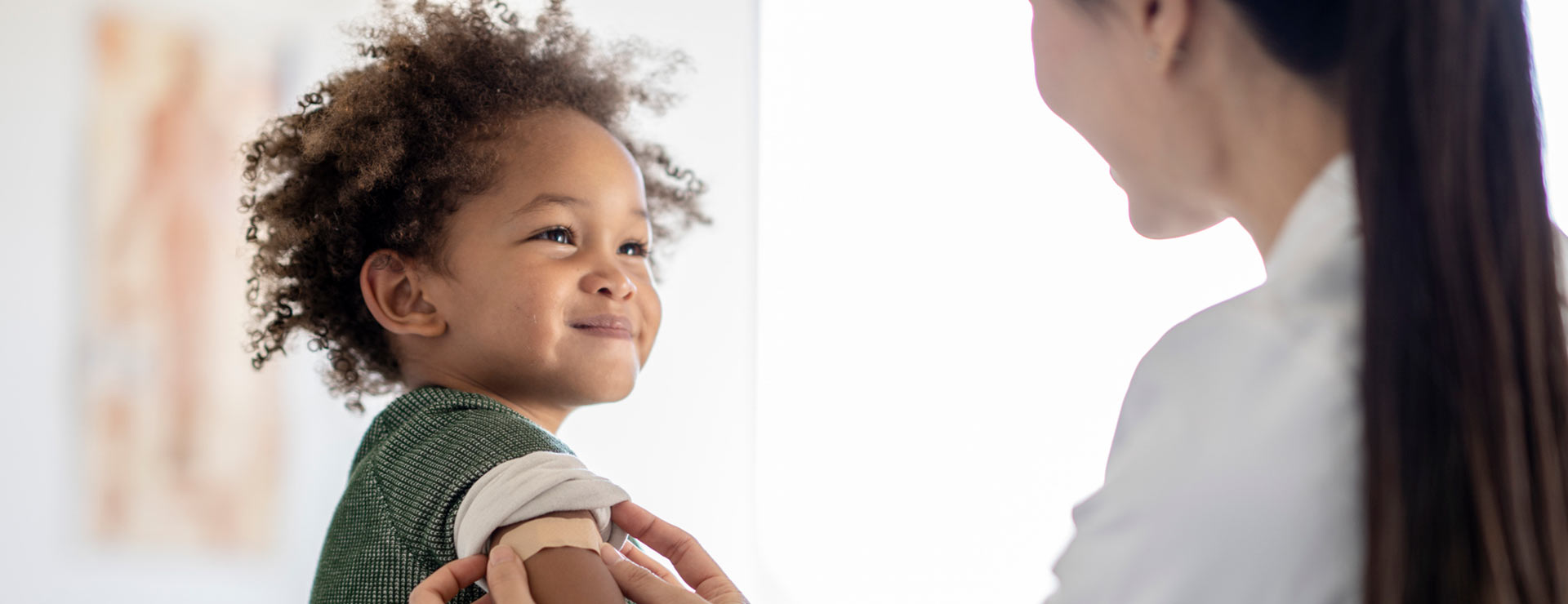 Child getting a bandage on his arm after receiving a vaccine