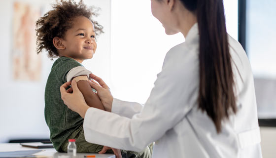 Child getting a bandage on his arm after receiving a vaccine