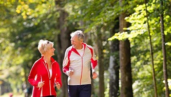 A senior couple jogs outdoors.