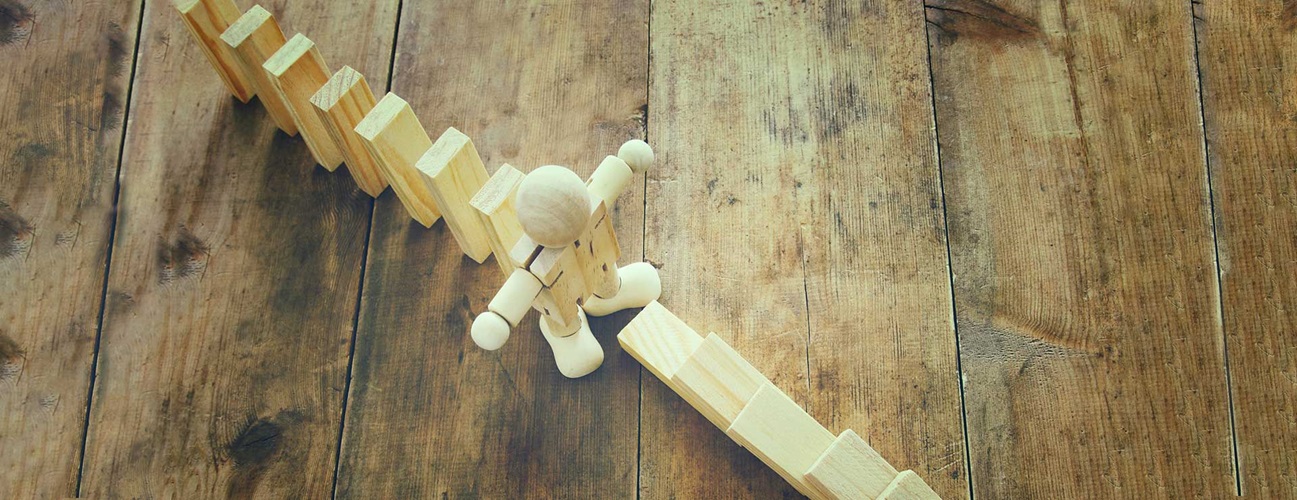 A wooden dummy stopping the domino effect