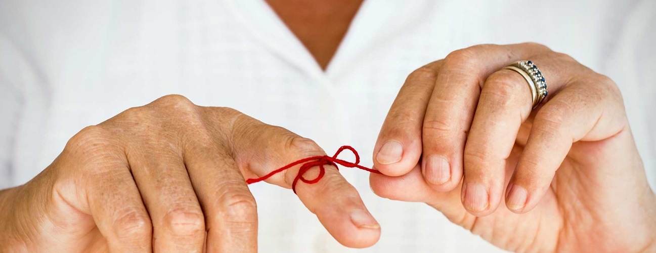 A red string tied around a finger as a reminder