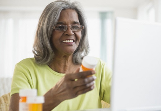 older african-american woman reading prescription label