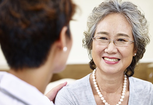 Woman smiling while talking with a doctor. 