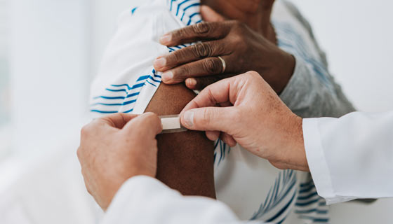 Woman getting a bandage on her new vaccine wound