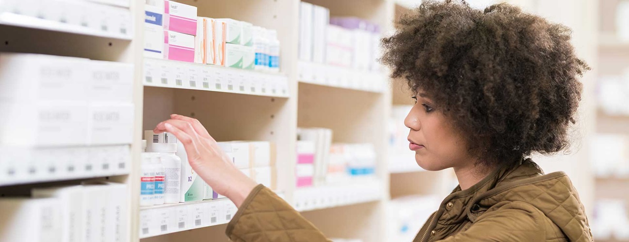 Woman browsing a pharmacy aisle.
