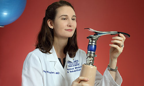 Mary Keszler holds a prosthetic leg