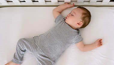 A baby asleep in their crib