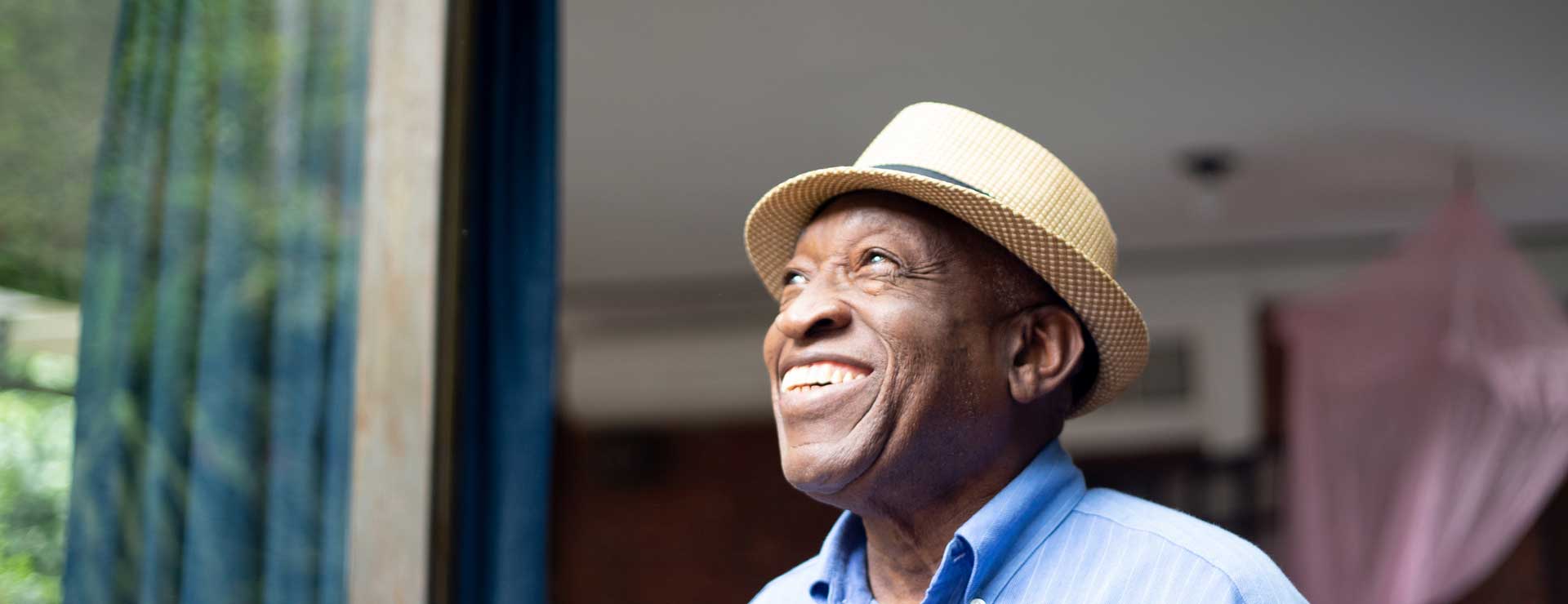 An elder man smiling looking up at the sky