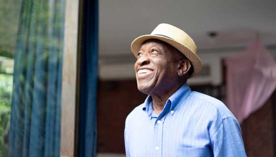 An elder man smiling looking up at the sky