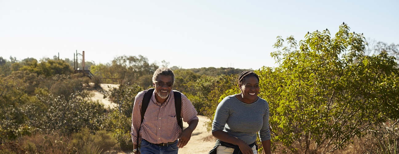 an older couple hiking along an outdoor trail