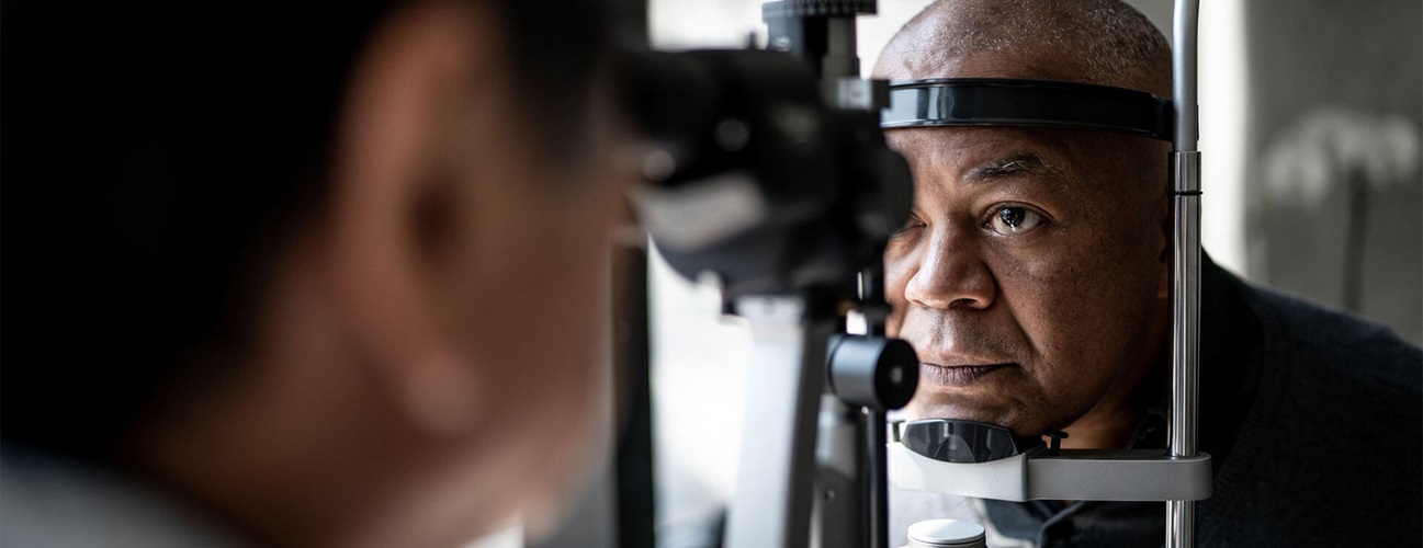 A man sits for an eye exam with a physician.