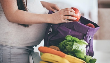 pregnant woman packing unpacking groceries