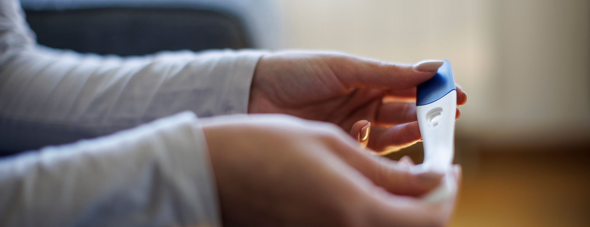 A woman's hands holding a pregnancy test