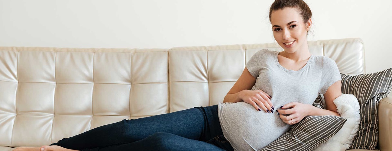 smiling pregnant woman on couch