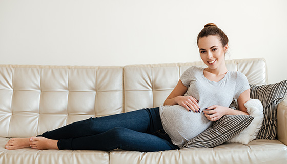 smiling pregnant woman on couch