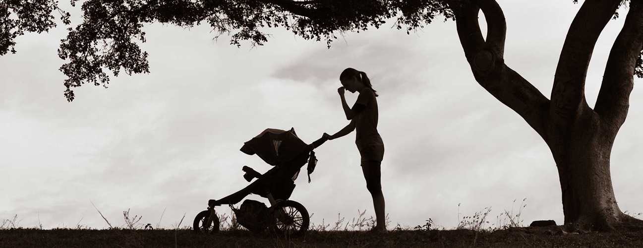 Woman in a park with baby in a stroller