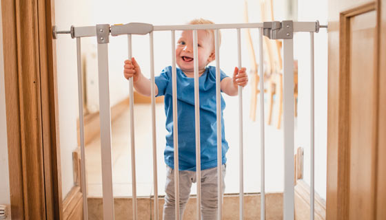 Baby safely behind a baby gate installed at home