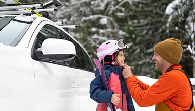 Dad helps daughter with skiing gear