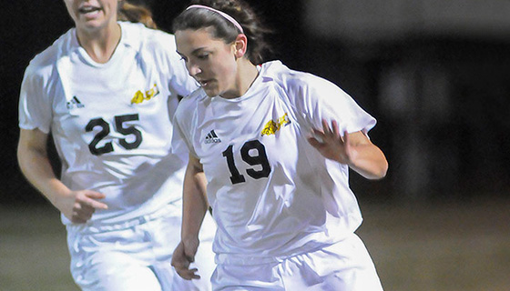 Two girls playing soccer
