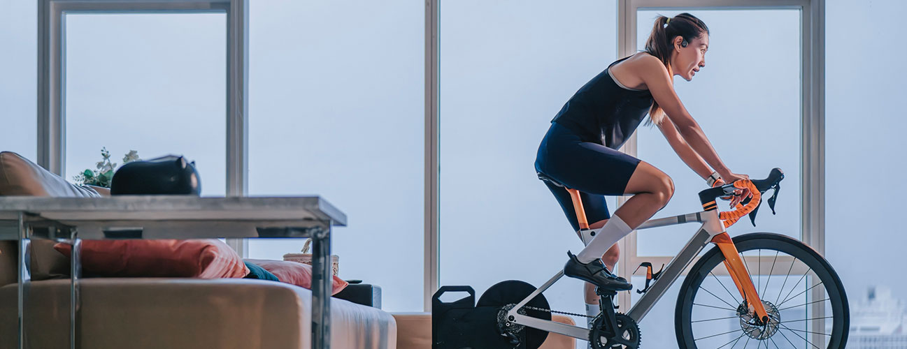 Woman uses a stationary bike in her living room