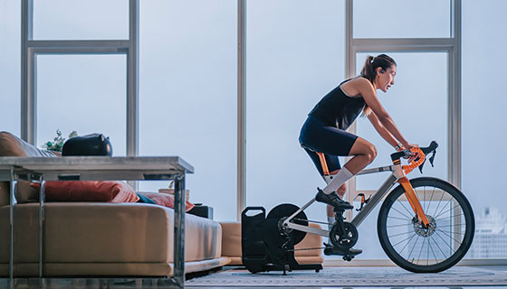 Woman uses a stationary bike in her living room