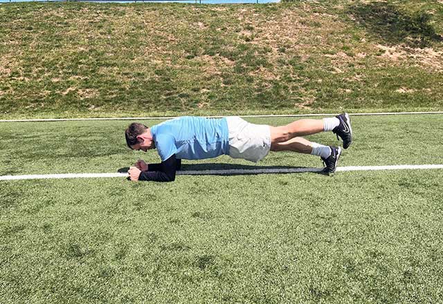 Image of John performing a plank with a leg lift.