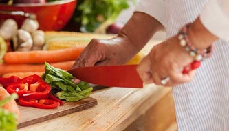 A woman chops vegetables.