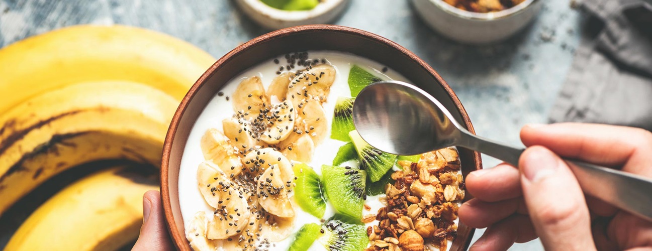 A healthy breakfast smoothie bowl of fruits and granola