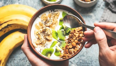A healthy breakfast smoothie bowl of fruits and granola