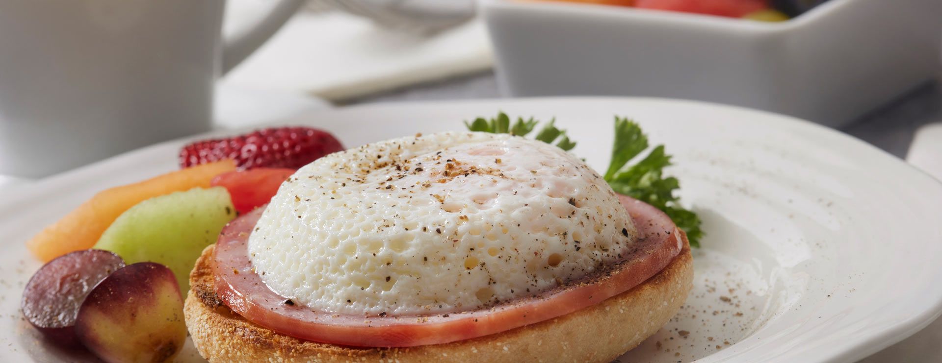 Healthy breakfast English muffin on a plate with fruit