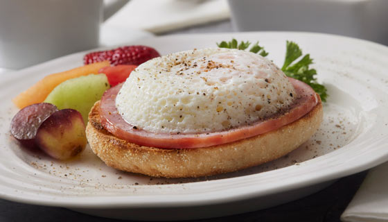 Healthy breakfast English muffin on a plate with fruit