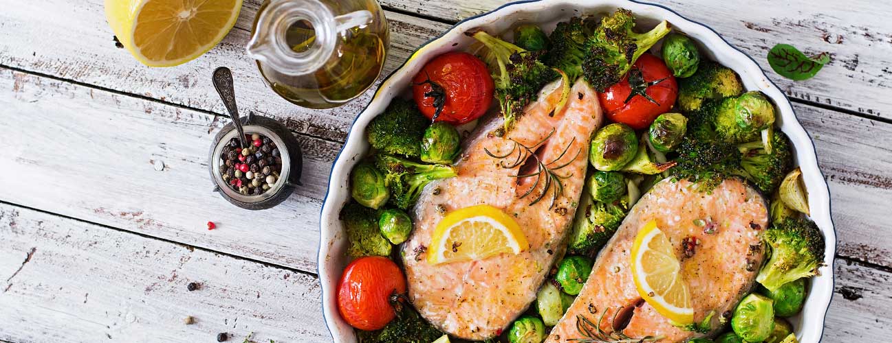 Grilled salmon sitting on a bed of veggies