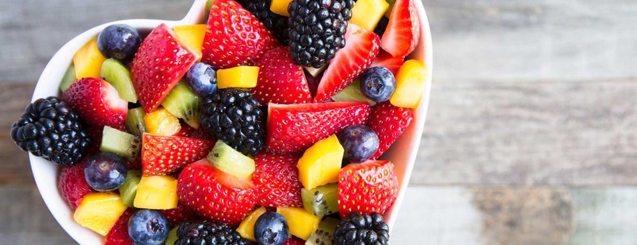 A heart-shaped bowl of colorful berries.