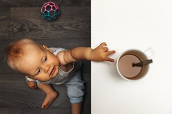 A baby reaching for a cup of coffee