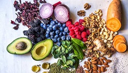 Healthy grains, fats, berries and legumes atop a gray marble countertop
