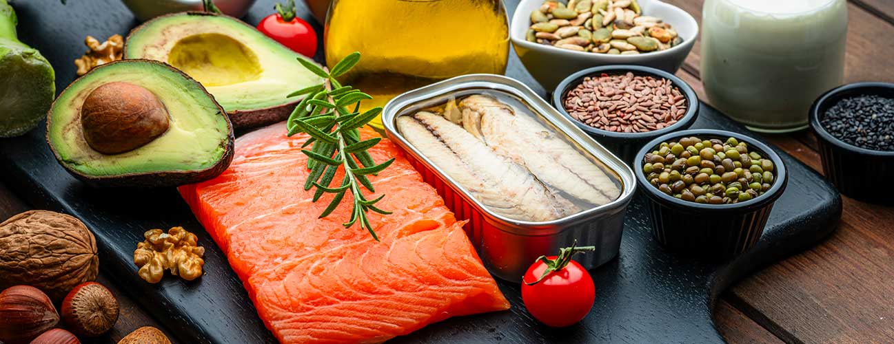 Spread of foods rich in healthy fats, including salmon, canned fish, nuts and avocados