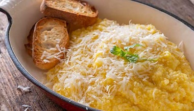 A plate of polenta topped with cheese.