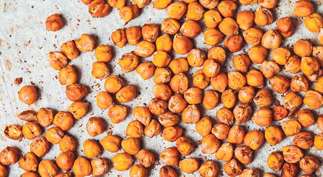 Roasted chickpeas splayed across a baking sheet.