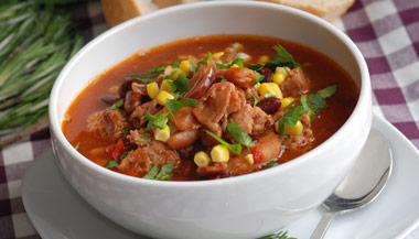 Bowl of healthy sausage and bean soup with vegetables
