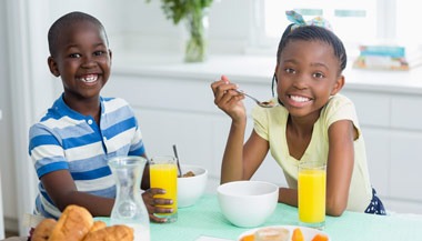 Siblings eating breakfast together