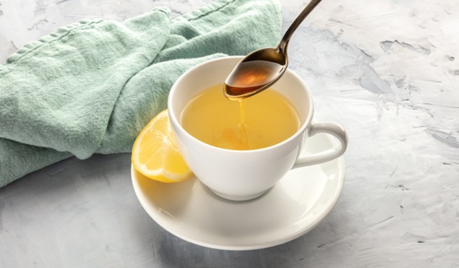 a cup of lemon water with honey