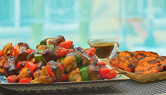 a plate of balsamic steak skewers with mixed vegetables