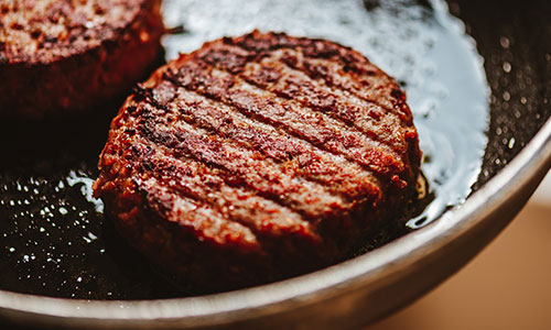 a black bean burger cooking in a skillet