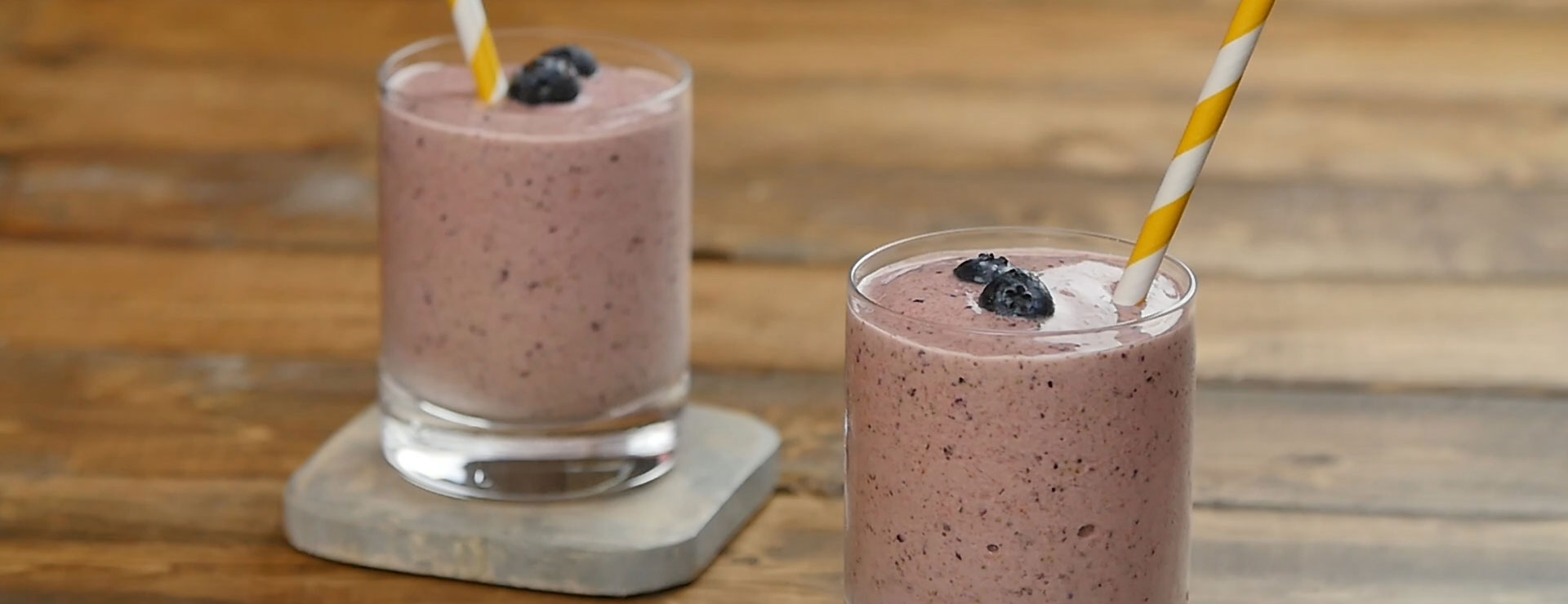 two smoothies in glasses with striped straws