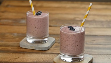 two smoothies in glasses with striped straws