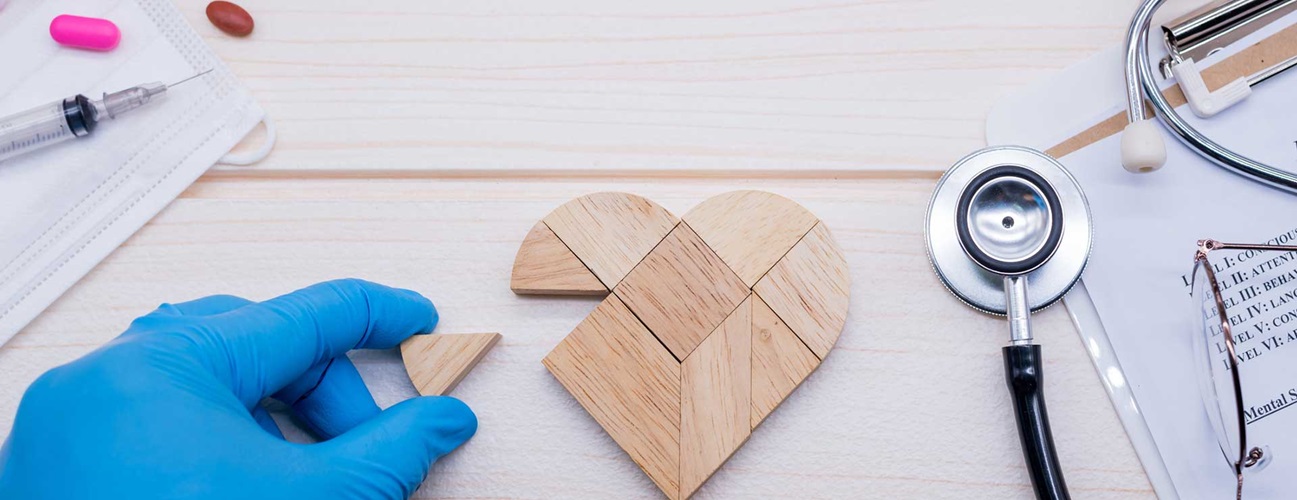 A doctor putting together a wooden heart-shaped puzzle