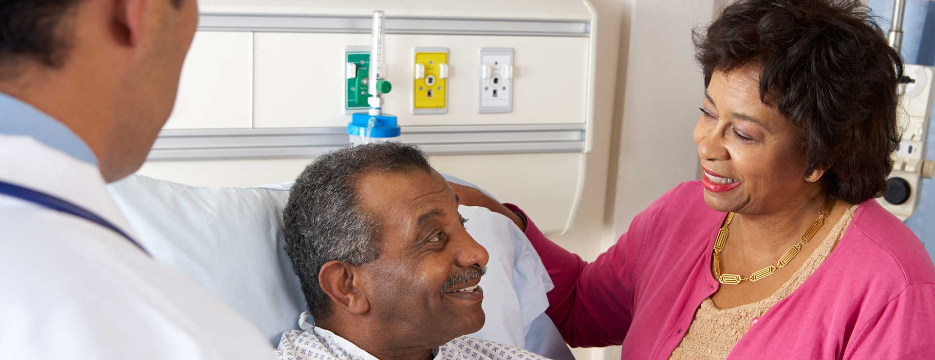 a couple speaking with doctor in a hospital room